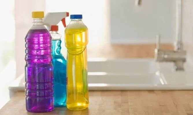 Botellas de limpiadores de colores junto a un lavaplatos